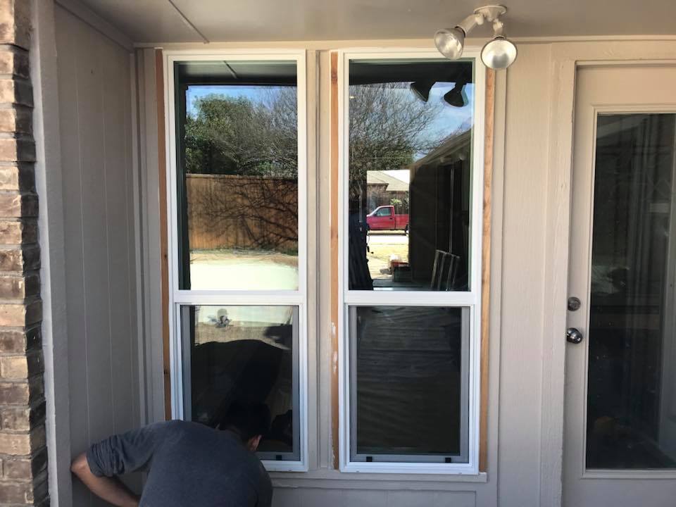 Technician measuring a window opening for replacement installation