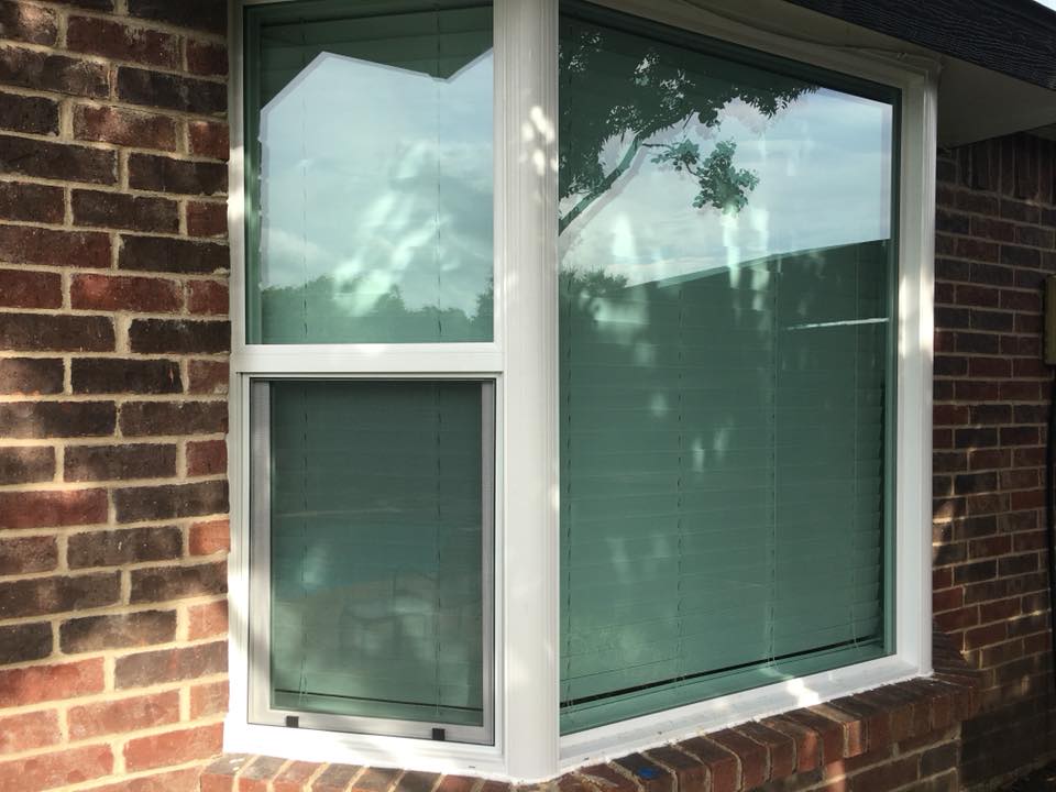 Window installer fitting a new replacement window into a home