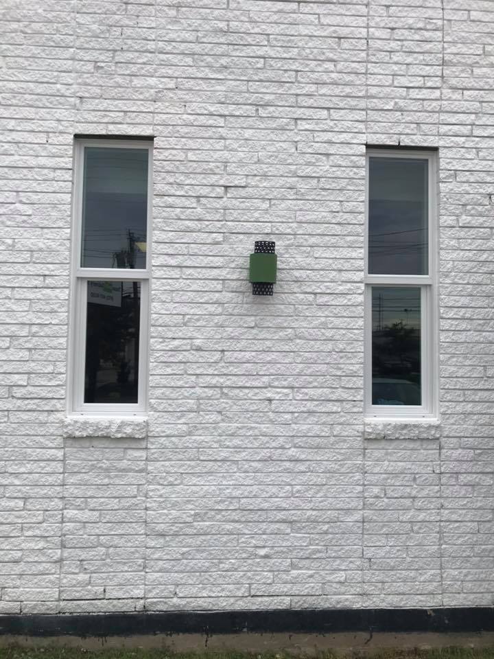 Newly installed white-framed windows on a brick home exterior