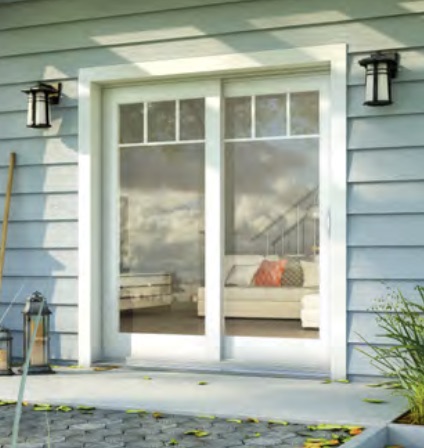 A sliding glass door with a view of a cozy living room and outdoor plants, flanked by two lanterns.